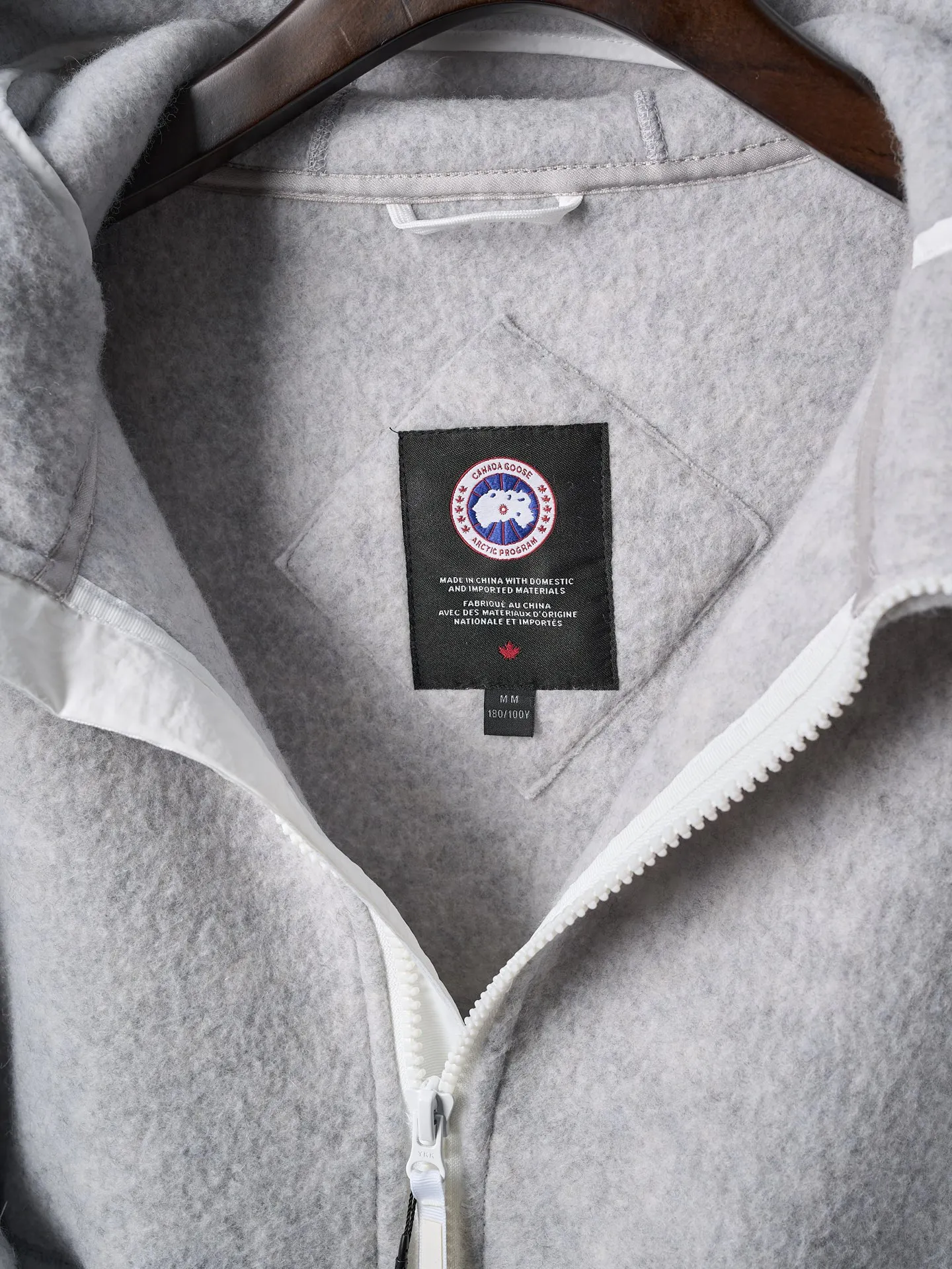 P780 Actual hanging auction] CANADA GOOSE/Canada Goose Chilliwack white label wool fleece hooded jacket [Ready stock] S M L XL Fabric selection: Wool fleece fabric made of wool as the main body and a very small amount of spandex and polyester fiber blended. Wool is a core natural ingredient that provides unparalleled temperature regulation, antibacterial and anti-odor properties and a skin-friendly feel. The feeding of a small amount of spandex gives the fabric a certain degree of four-way elasticity, making it non-restrictive during daily activities. As the basis of fleece's structure, polyester fiber enhances the fabric's durability, wrinkle resistance and quick-drying properties. It contributes to the loft of the fleece and provides functions such as trapping air.  Detail 1: The sleeves and hem are closed with 2×2 ribbing. Its strong elasticity can closely fit wrists and waists of different thicknesses, forming an effective 'seal' to prevent cold wind from blowing back. It can still maintain its original shape after repeated stretching and use, and is not easy to loose and deform. And the ribbed cuffs can convey a sense of design and enhance the visual beauty.  Detail 2: The combination of hood design and elastic buckle improves warmth and windproof performance when wearing.